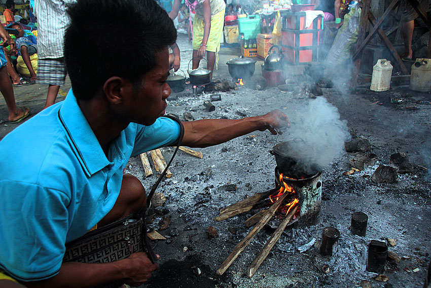 A Manobo tribesman cooks rice for his family at the Buhangin gymnasium. The Davao City government has opened its various gymnasiums for tribal residents seeking Christian charity during the Yuletide. (Ace R, Mroandante/davaotoday.com)