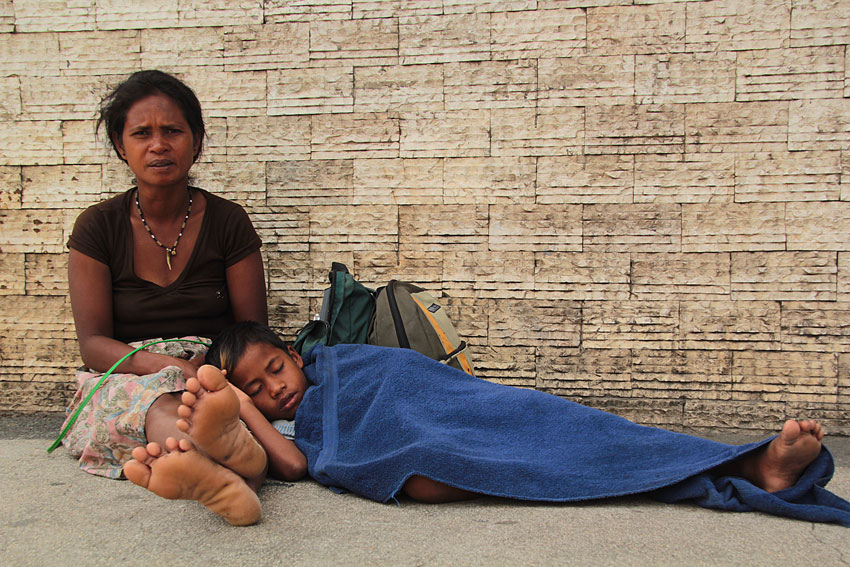 Merly Salag, 39-year-old Manobo tribal resident of Barangay Mapula, Paquibato District, in northern Davao City takes care of his son, Rosal, 7, due to fever, along the road of Buhangin. (Ace R. Morandante/davaotoday.com)