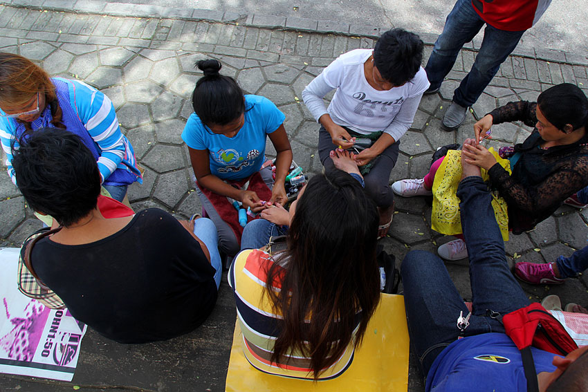 A group of women manicurists along San Pedro street clean the foot nails of their clients.  (Ace R. Morandante/davaotoday.com)