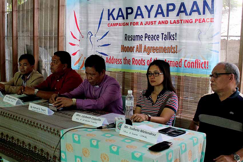 Lijobeth Coquilla, wife of NPA captive jail warden Jose Mervin Coquilla, appeals for the release of her husband Thursday. She is accompanied by Compostela Valley Province executive assistant Isabelo Melendrez and peace group Exodus for Justice and Peace. (Medel V. Hernani/davaotoday.com)