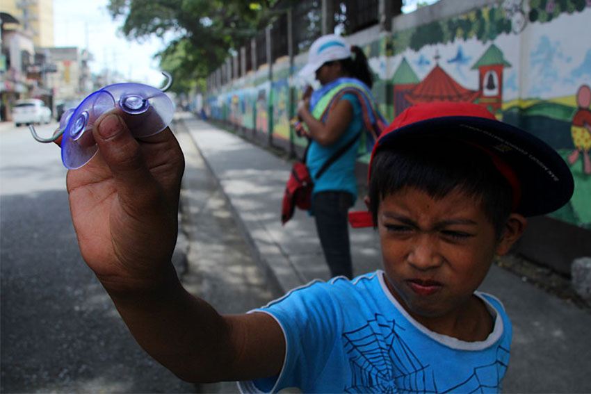 A boy and his mother make a living by selling signboard holders and towels to jeepney drivers plying along Ponciano Reyes Street. (Ace R. Morandante/davaotoday.com)