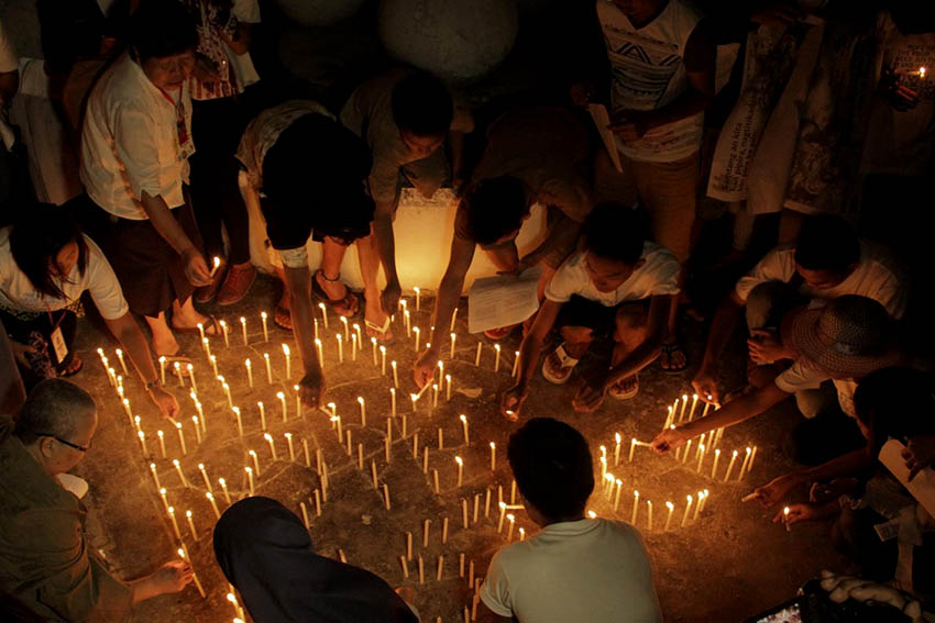 A member of the Sisters Association in Mindanao lights a candle praying for Pope Francis to join the typhoon survivors'quest for justice. (Contributed photo: Dexter Aserdano)