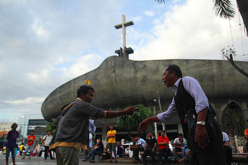 So-called faith defenders from the Jehovah's Witness and Roman Catholic argue in front of San Pedro Cathedral on which one is the real religion. (Ace R. Morandante/davaotoday.com)