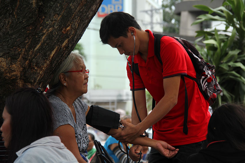 While waiting for a job as a graduate of a caregiving course, Richard Velarde, 24, earns a living taking blood pressures from people at the Centennial Park infront of the Davao City Sangguniang Panglungsod. (Ace R. Morandante/davaotoday.com)