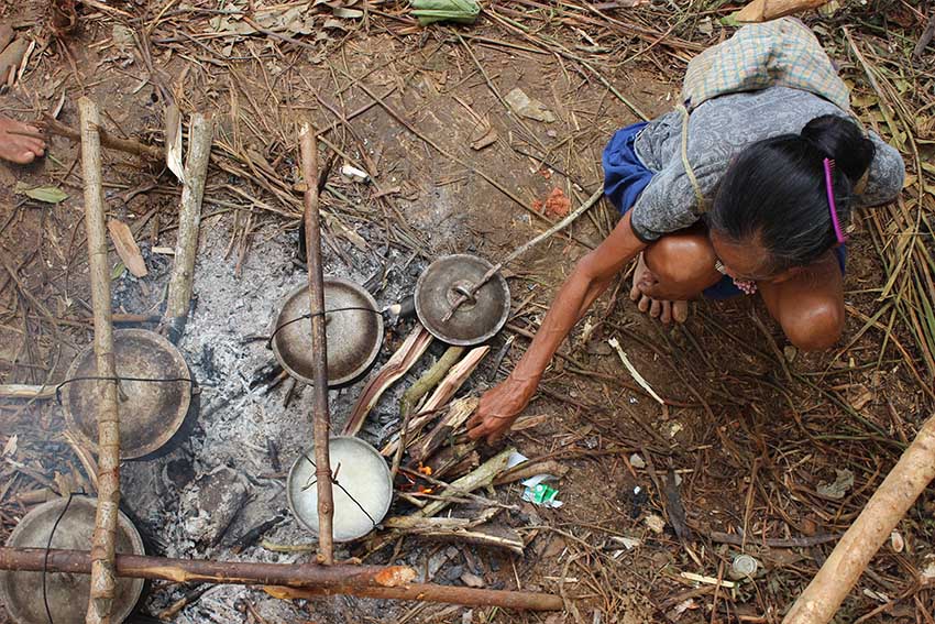 A Banwaon woman is cooking rice for her family in the evacuation center in Barangay Balit, San Luis, Agusan del Sur where more than 900 individuals are housed. (Contributed photo)