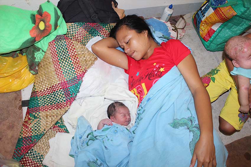 A mother sleeps with her newborn baby inside the evacuation center in Barangay Balit, San Luis Agusan del Sur. (Contributed photo)