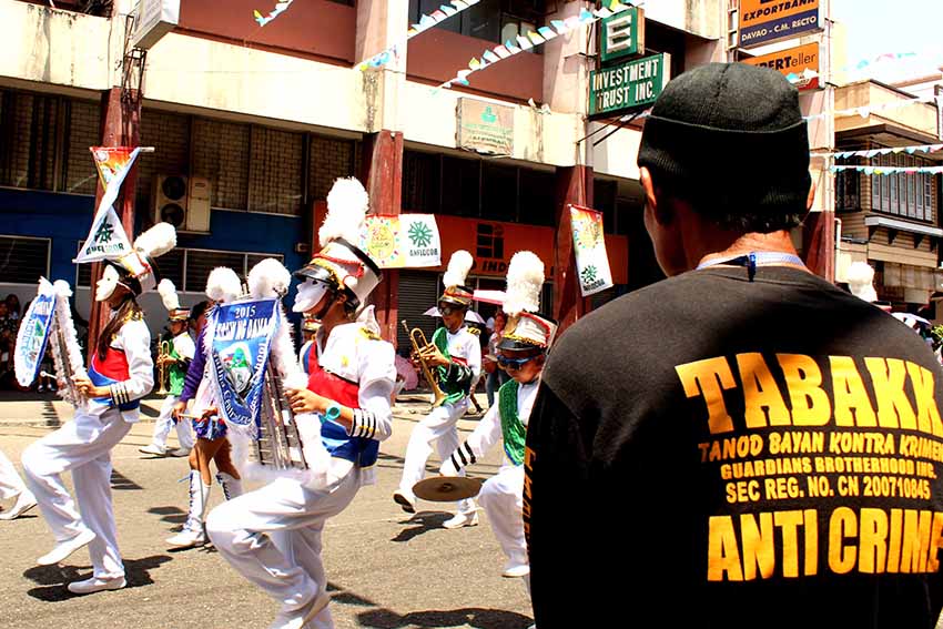 Anti-crime civilian volunteer actively watches the flow of the participating contingents from different schools and establishments along C. M. Recto. (Medel V. Hernani/davaotoday.com)