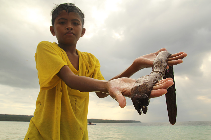 This young boy a son of a fisherman in Penaplata shows his catch, a small eel, which, he said, is for their lunch. (Ace R. Morandante/davaotoday.com)