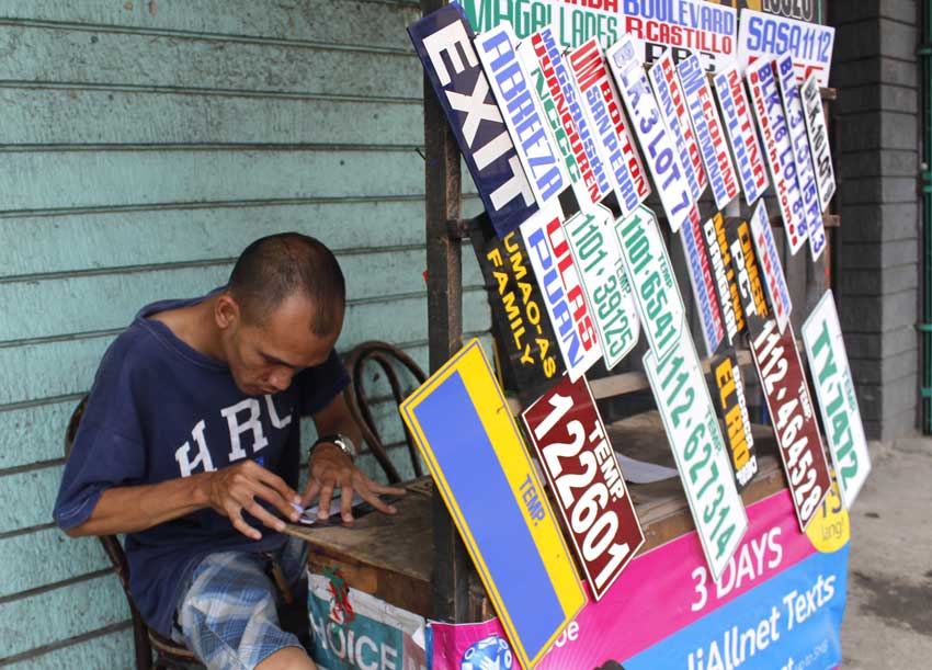 CRAFTSMAN. A signboard maker along C. M. Recto, meticulously cuts through plastic board for sign board patterns. He produces at least ten pieces of jeepney signboard each day and sells it at fifty pesos each. His wife said his income is not enough for their family, "most of the time."