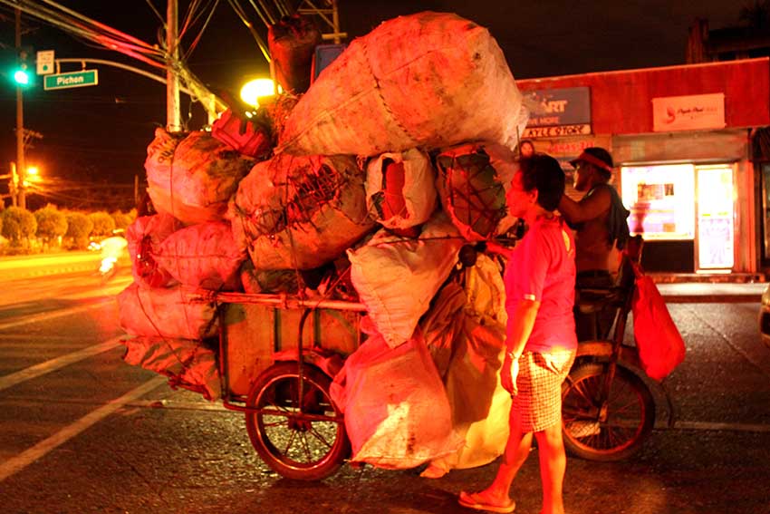  A couple, waiting for the green traffic light along Quimpo Boulevard, starts their work early in the morning to sell scrap materials at a junkshop in Agdao. (Medel V. Hernani/davaotoday.com)