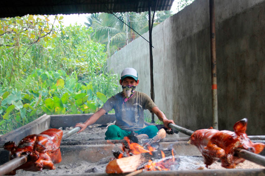 A man roasts two pigs at the same time along Bonifacio Street, Tagum City on Saturday afternoon, a day before Catholics observed the Palm Sunday. (Johannes Paul R. Garado/davaotoday.com)