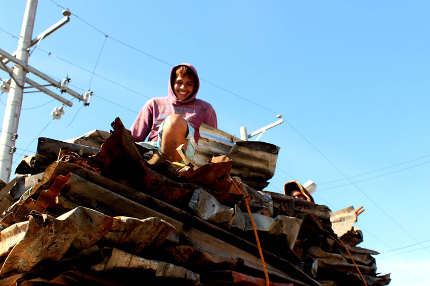 A happy buyer of scrap iron roof mounds loads on to a truck.