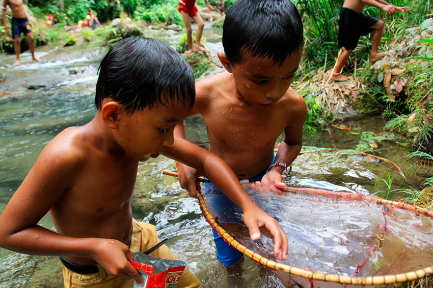 These two young boys hunt for prawns, or ulang in local dialect, as they enjoy their vacation in Hagimit falls in the Island Garden City of Samal. (Ace R. Morandante/davaotoday.com)