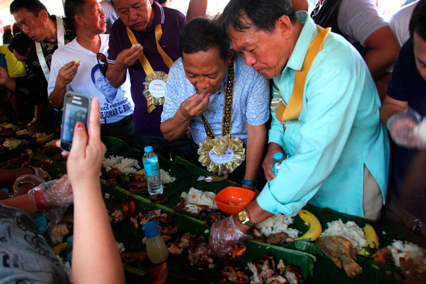 A woman tries to take a shot of Vice President Jejomar Binay who ate along Carmen Vice Mayor Alberto Sarin from her cellphone.(Ace R. Morandante/davaotoday.com)