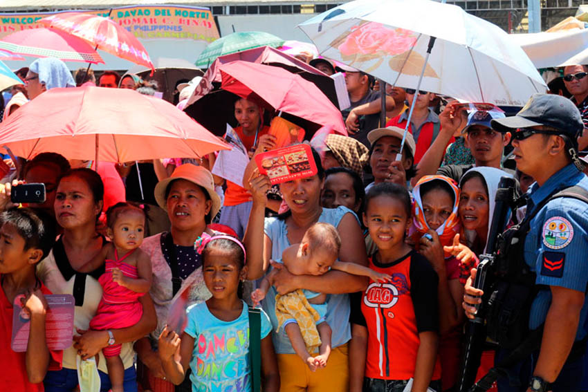 A mother whose 6-month old baby has a swelling neck is among the crowd who waited for the arrival of Vice President Jejomar Binay during his visit in Carmen, Davao del Norte. They were hoping to get help for the medication of her baby. (Ace R. Morandante/davaotoday.com)