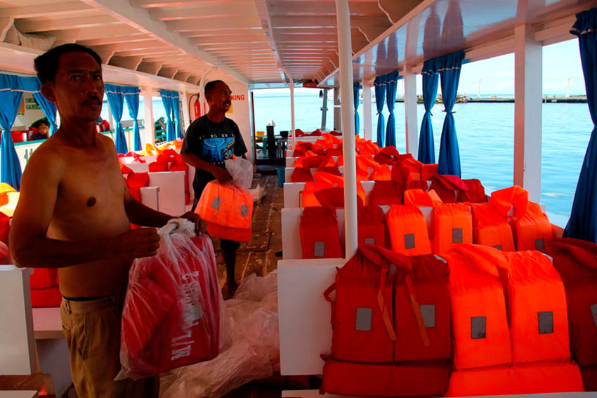A crew of a transport vessel in Sta. Ana wharf immediately changes old life jackets to new ones and put it in the seats as city council officials make rounds for ocular inspection on Wednesday. (Ace R. Morandante/davaotoday.com)