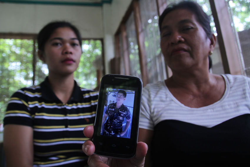 Mother Lucia Subere (right) shows the photo of her son, Private First Class Khen Subere of the 27th Infantry Battalion, who is being held prisoner-of-war of the New People's Army. She begs for the immediate release of his son as he is the one who helps their family's needs. (Ace R. Morandante/davaotoday.com)