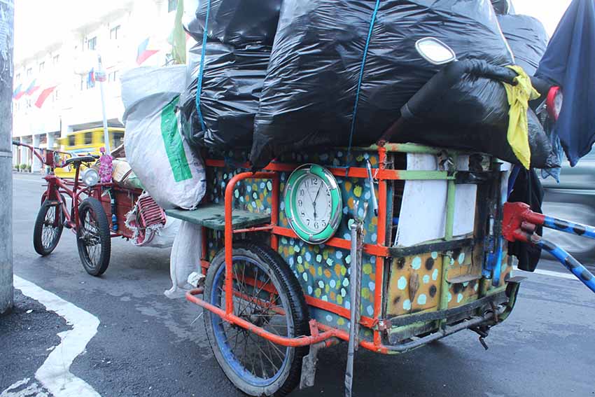 One early Friday morning, Alcarlito Lampios parks his trisikad of collected trash, mainly recyclable materials, for a cup of coffee and pan de sal along Magallanes, Street in Davao City. 