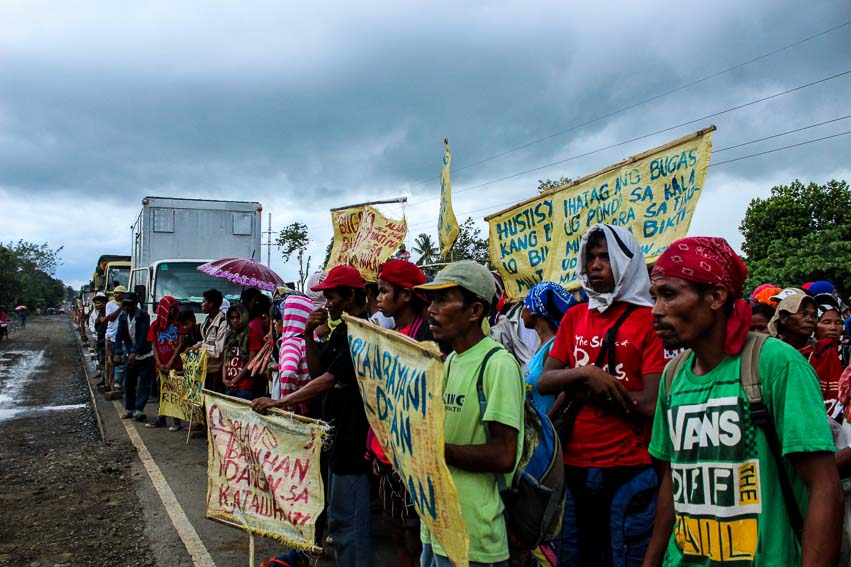 Amidst the rain on Tuesday, farmers from the 11 barangays of drought-stricken Kitaotao, Bukidnon put up a barricade along Davao-Bukidnon highway to demand the release of the P8.9 million calamity fund from the government. They also demand justice for Emelio B. Roflo, a farmer allegedly beaten to death by the military. (Paulo C. Rizal/davaotoday.com)