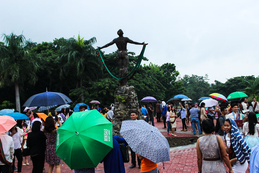 Graduates from the University of the Philippines Mindanao today bring umbrellas to protect themselves from the rain while waiting to get their own picture in front of the iconic oblation statue. The class of 2015 is the first batch of students to graduate on the rainy month of June in accordance to the UP System's shifting of the academic calendar from June-April to August-May in its goal of "maximizing the opportunities offered by ASEAN integration and global education partnerships." (Paulo C. Rizal/davaotoday.com)