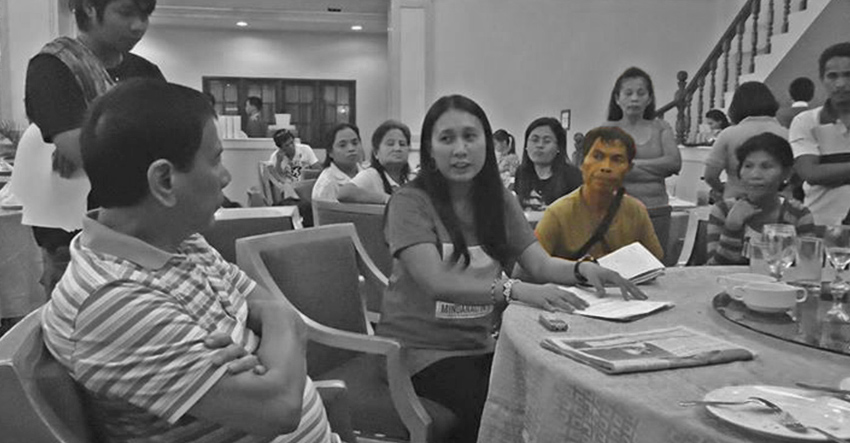 Ruben Enlog (in brown shirt) listens with Mayor Duterte to Hanimay Suazo of Karapatan-SMR. (photo from https://karapatansmr.wordpress.com)