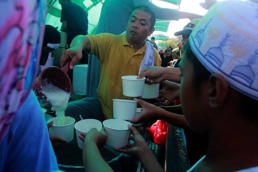 MEAL. Muslims in Davao City partake cauldrons of hot porridge after their prayer marking the end of Ramadan on Friday Morning.  \\