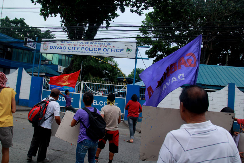 Activists throw tomatoes toward the entrance gate of Davao City Police Office as they condemn what they claim as "police brutality" for the commotion inside the United Church of Christ in the Philippines Haran compound on Thursday. (Ace R. Morandante/davaotoday.com)