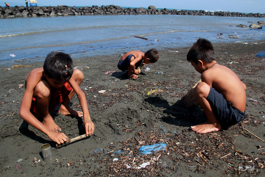 Children from Barangay 23-D in Davao City scour the shore along Isla Verde's coastal line for small shell fishes to cook for lunch. (Ace R. Morandante/davaotoday.com) 
