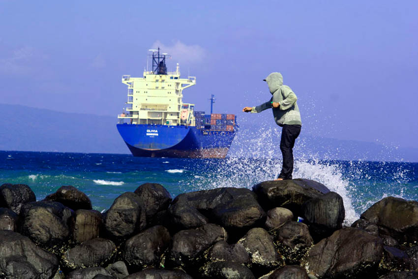 This young boy tries his luck in catching a fish amid the big waves in Isla Verde, Davao City. (Ace R. Morandante/davaotoday.com)