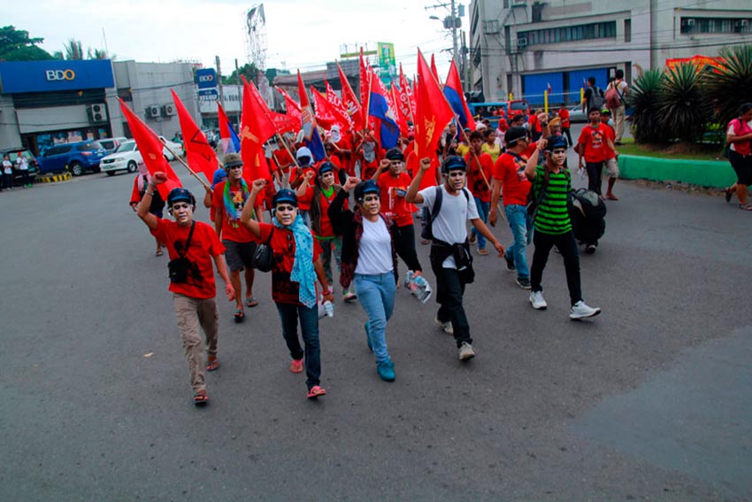 MARCHING PARAGOS. Sympathizers wear masks of NPA's Kumander Parago's image during his funeral march around downtown Davao City.(Ace R. Morandante/davaotoday.com)