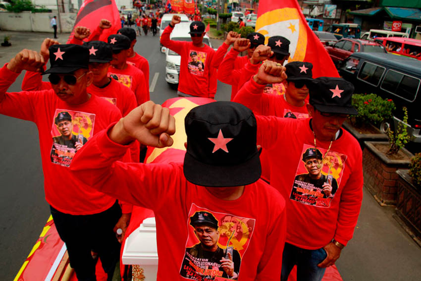 CLENCHED. Escorts of the late Commander Parago raise their fists during the funeral march on Friday. (Ace R. Morandante/davaotoday.com)