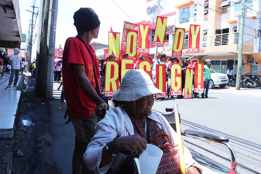 Senior citizens brave the heat of the sun begging along San Pedro Street, Davao City for loose change as militants march for their version of the People's State of the Nation Address (SONA) on Monday. (Medel V. Hernani/davaotoday.com)