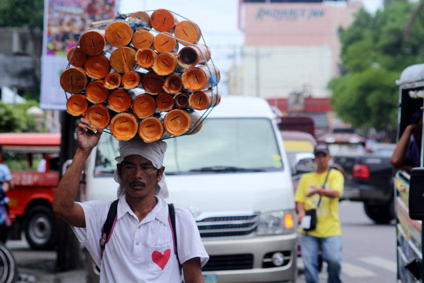 A man carry on his head a huge bamboo coin in dowttown area of the City to sell. (Ace R. Morandante/davaotoday.com)