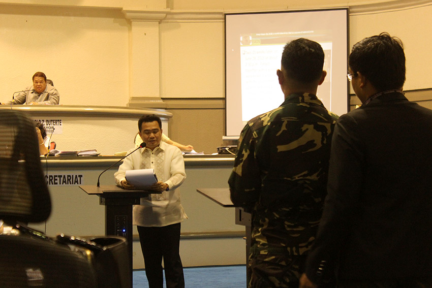 Councilor Bernard Al-ag reads to First Lieutenant Christopher Santos two of the three resolutions of the City Council committee on human rights regarding the Paquibato 'massacre' last June 14 that would affect him including his proposed transfer outside Davao City and the recommendation of filing of murder charges against him. (Earl O. Condeza/davaotoday.com)