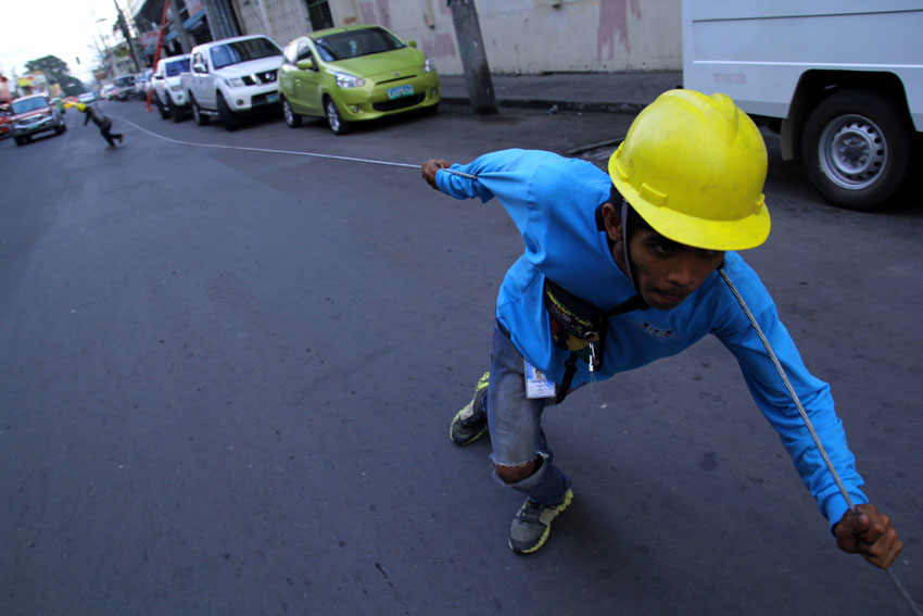 A cable man pulls the cable wire to connect it to an internet post along Ponciano Street. (Ace R. Morandante/davaotoday.com)