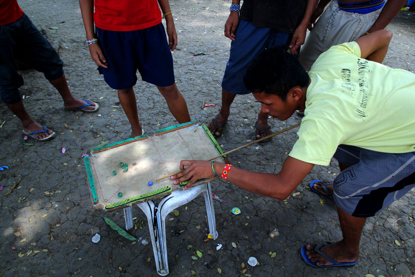Manobo evacuees play billiards using marbles and a mini board inside a church compound here where they have been staying for the last five months. (Ace R. Morandante/davaotoday.com)