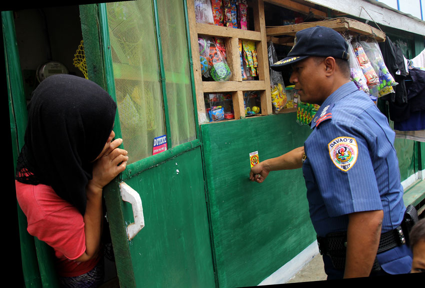 Davao City Police Office (DCPO) director Senior Superintendent Vicente D. Danao Jr takes the lead in posting stickers outside residences in Barangay 23-C as part of the campaign against drugs dubbed "KATOK Droga" (Katilingban Og Kapulisan Kontra Droga). (Ace R. Morandante/davaotoday.com)