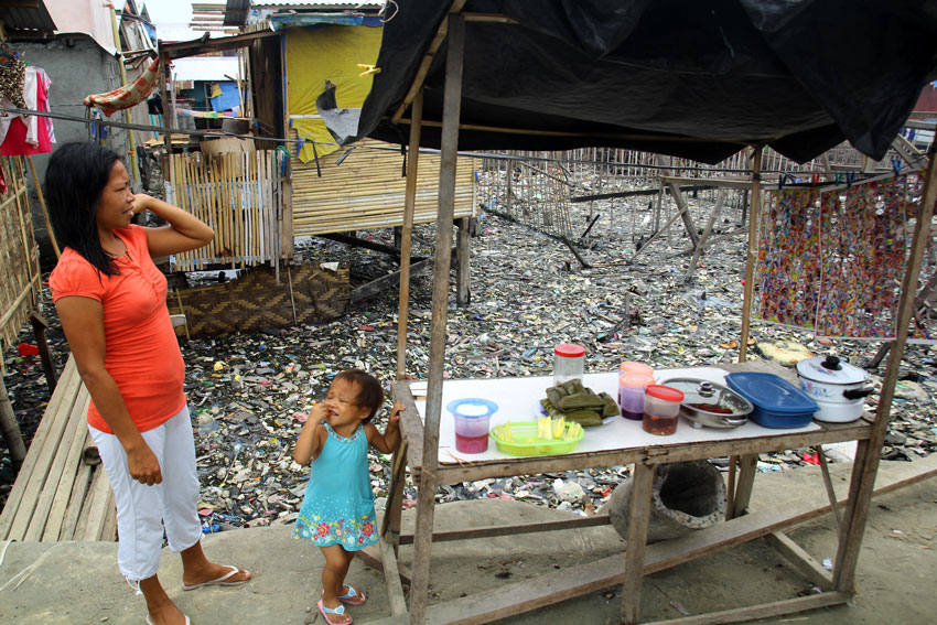 > A mother with her child attends to their mini store in Boulevard. (Ace R. Morandante/davaotoday.com) 