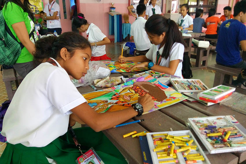 A high-school student from Davao City National High School finishes her poster which shows an image of a crying Lumad. The student is among those who joined the Literary and Arts Festival sponsored by the Save Our Schools Network held at the University of the Immaculate Conception Wednesday. (Earl O. Condeza/davaotoday.com)