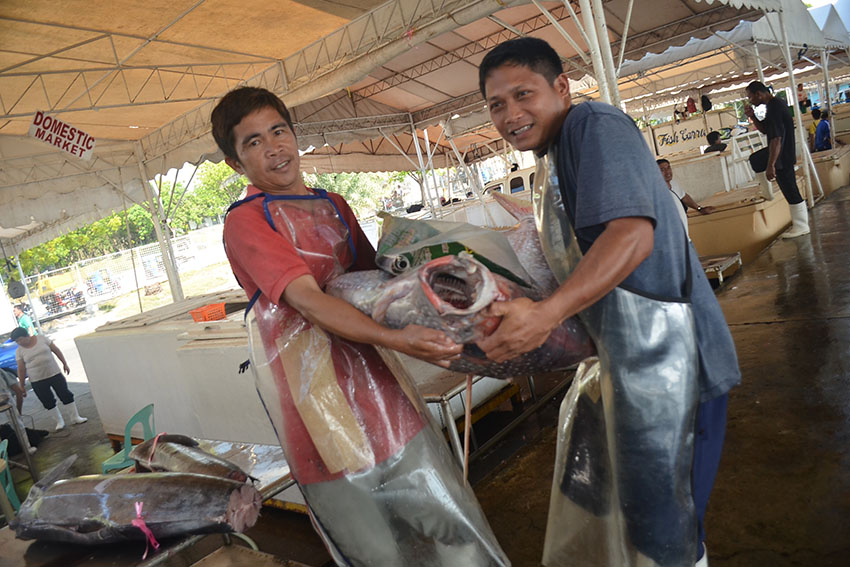 Laborers are carrying a 74-kilo Diana (Moonfish) for export inside the market of the Fish Port Complex in General Santos City on a Sunday. (Zea Io Ming C. Capistrano/davaotoday.com)