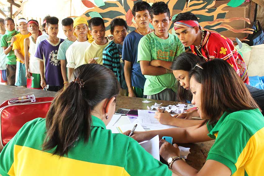 Staff of Davao Social Workers and Development Office, do the listing of the names  of evacuees at Haran compound and distribute the claim stub for the relief good. (Medel V. Hernani/davaotoday.com)