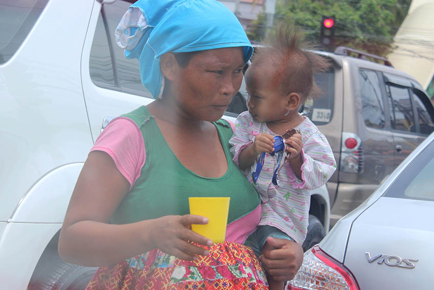 A pregnant woman and her son brave the searing heat of the El Niño dry spell as she begs for loose change along JP Laurel, corner Cabaguio Avenue, Agdao, Davao City. (Medel V. Hernani/davaotoday.com)  