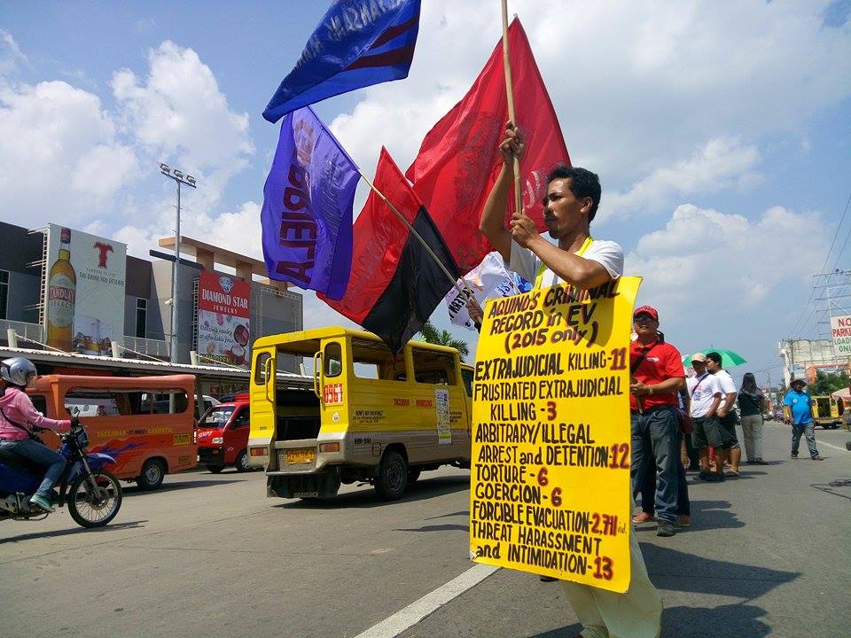 RECORD. A protester holds a placard of the record of human rights violations in Eastern Visayas this year during a protest action held in Tacloban City on Thursday. (Earl O. Condeza/davaotoday.com)