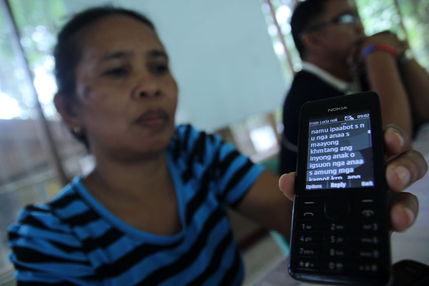 Lucia Añover, mother of Pfc. Marjon Añover, who is held prisoner by the New People's Army in Compostela Valley province shows the forwarded text message that assures her not worry  "because he is in good hands". The mother has appealed to the NPA to immediately release her son. (Ace R. Morandante/davaotoday.com)