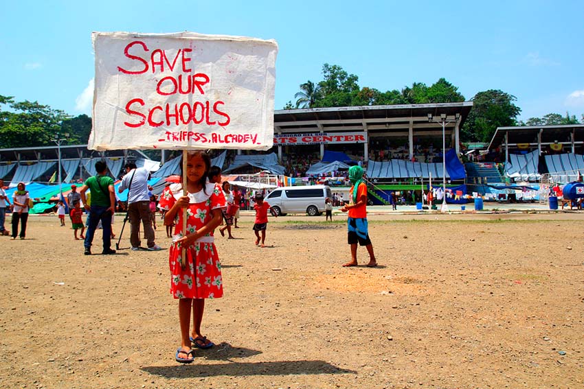 A grade 5 pupil of Alcadev school holds a placard during the visit of Senator Teofisto Guingona in the evacuation center in Tandag City sports complex in this capital of Surigao del Sur. (Ace R. Morandante/davaotoday.com)