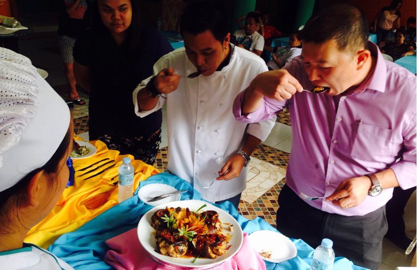 JUDGES. Potcholo Mercado, food and beverage manager of Park Inn by Radisson Davao (right) and Gerard Piansay, a sous chef of Chippen's Cafe in Davao City (second from right) taste the dishes prepared by culinary students during the 11th Pantatan Festival Culinary Competition held Thursday morning in Barangay Los Amigos, Tugbok District, Davao City. (Zea Io Ming C. Capistrano/davaotoday.com)