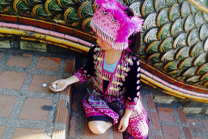 HILLTRIBE GIRL. She is one of the little girls who is seen waiting below the stairs going to Wat Phrathat Doi Suthep. Tourists who wish to take their picture with the girls are asked to give some coins.