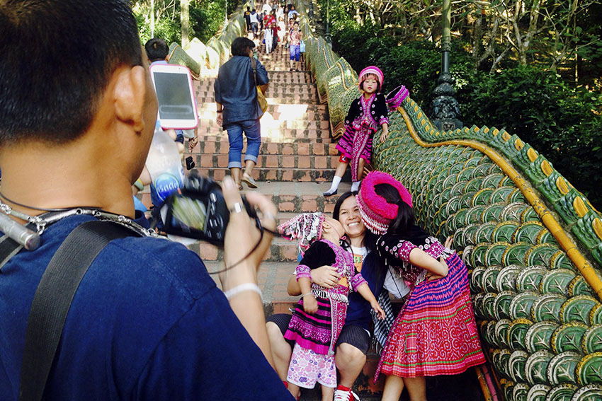 TOURISTS. A couple takes photo with the young girls of a hilltribe donning their traditional clothes just below the 309 steps Naga stairs that lead to the temple.