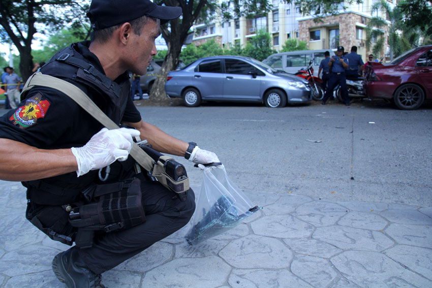 FRAGMENTS. A swat officer collects fragments as evidence from the bomb explosion in the passenger van which exploded in Ecoland, Davao City Wednesday morning. (Ace R. Morandante/davaotoday.com)