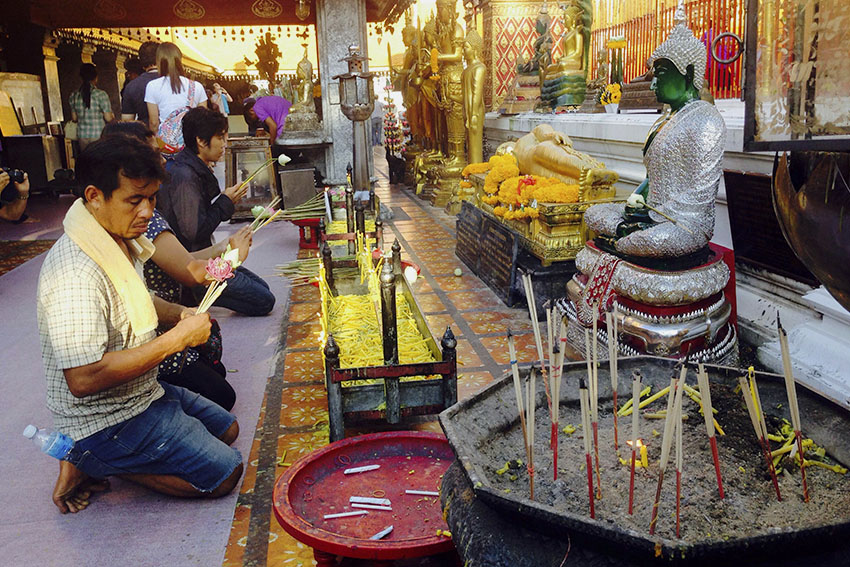 WORSHIPPERS. Believers of Buddha pay respect to him by offering prayers inside the Wat Phrathat Doi Suthep.